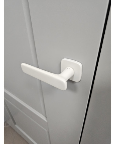 Poignée de porte ivoire mat FLOW poignée design vue de haut montée sur une porte