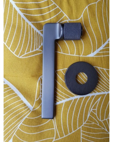 Poignée de porte Mandelli Grint poignée design couleur 5 vue de côté sur un fond à motif