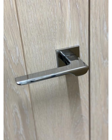 Poignée de porte chrome poli LIGNE poignée design vue de haut  inclinée montée sur une porte