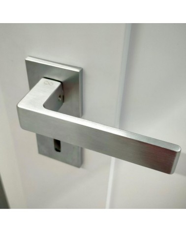 Poignée de porte chrome brossé Apollo poignée design vue de haut inclinée montée sur une porte
