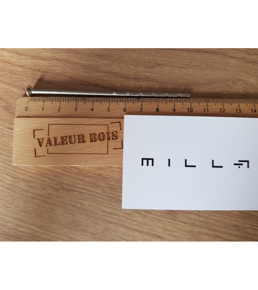 Tige filetée traversant M4 de 10cm de longueur sur une table, avec une règle en bois et carte de visite blanche  millapoignees