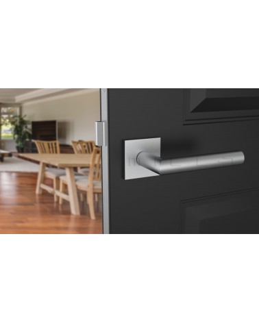 Poignée de porte chrome satiné ARABIS quincaillerie design montée sur une porte entrouverte