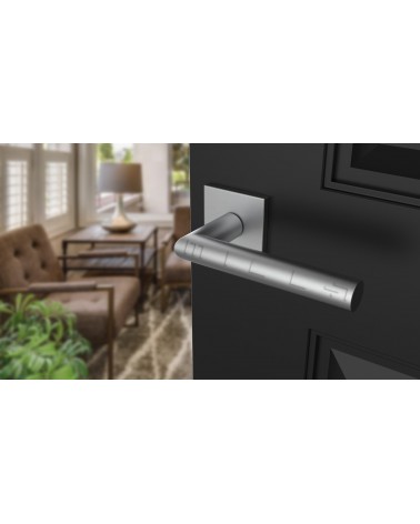Poignée de porte chrome satiné ARABIS quincaillerie design montée sur une porte légèrement ouverte