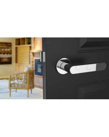 Poignée de porte chrome poli ALORA poignée design vue de face montée sur une porte entrouverte