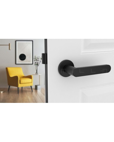 Poignée de porte noire ALORA poignée design vue de face montée sur une porte entrouverte