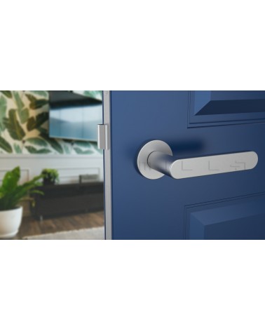 Poignée de porte chrome satiné ALORA poignée design vue de face montée sur une porte entrouverte