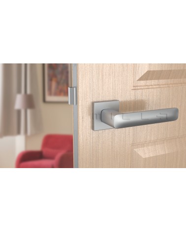 Poignée de porte chrome satiné STELLA poignée design vue de face montée sur une porte