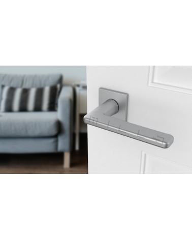 Poignée de porte chrome satiné SETIA poignée design vue de haut inclinée montée sur une porte