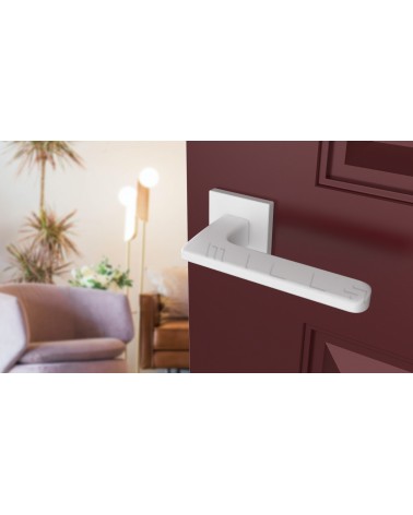 Poignée de porte blanche YUKA quincaillerie design vue inclinée montée sur une porte