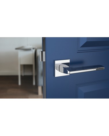 Poignée de porte chrome poli YUKA quincaillerie design vue de face montée sur une porte