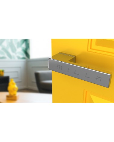 Poignée de porte chrome poli CARLINA poignée design vue de haut inclinée montée sur une porte