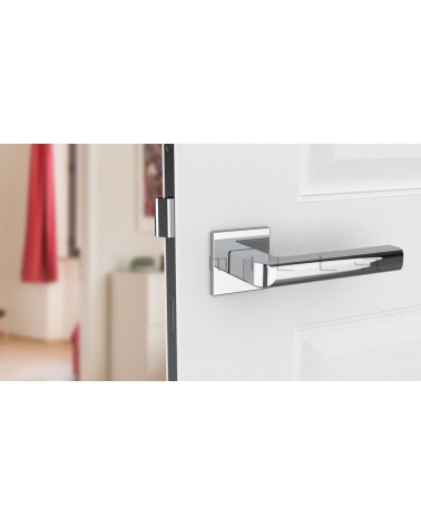 Poignée de porte chrome poli SALICE quincaillerie design vue de face montée sur une porte