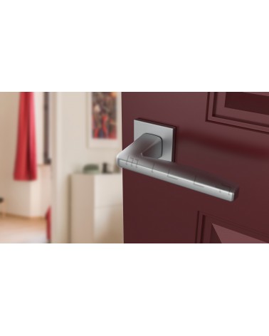 Poignée de porte chrome satiné ERBA poignée design vue inclinée montée sur une porte