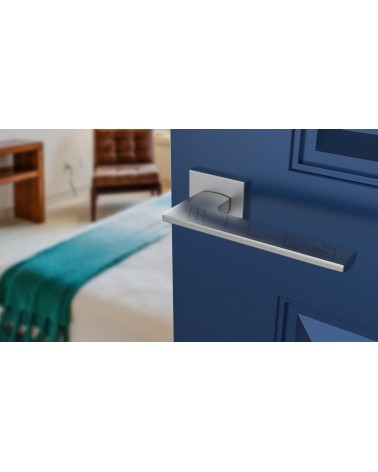 Poignée de porte chrome satiné LUNARIA poignée design vue de haut inclinée montée sur une porte