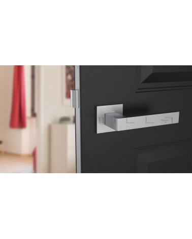 Poignée de porte chrome satiné SULLA poignée design vue de face montée sur une porte