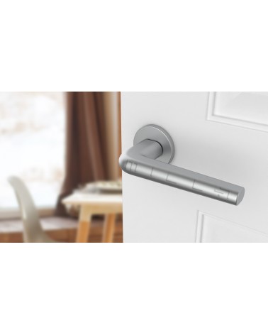 Poignée de porte chrome satiné FUNKIA poignée design vue de haut inclinée montée sur une porte