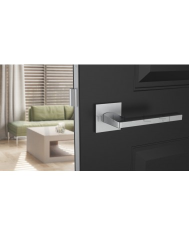 Poignée de porte chrome satiné PYROLA quincaillerie design vue de face montée sur une porte
