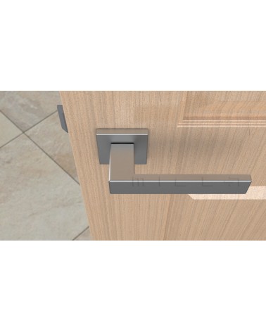 Poignée de porte chrome satiné PINA poignée design vue de haut montée sur une porte