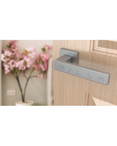 Poignée de porte chrome satiné PINA poignée design vue inclinée montée sur une porte