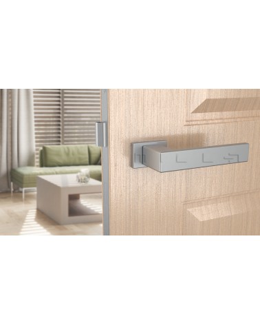 Poignée de porte chrome satiné PINA poignée design vue de face montée sur une porte
