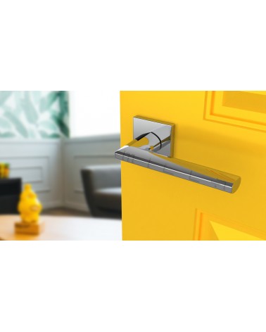 Poignée de porte chrome poli JASMINA poignée design vue inclinée montée sur une porte