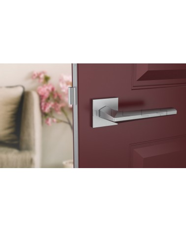 Poignée de porte chrome satiné JASMINA poignée design vue de face montée sur une porte