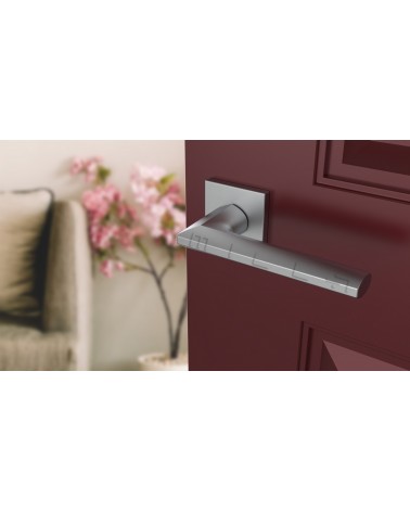 Poignée de porte chrome satiné JASMINA poignée design vue inclinée montée sur une porte