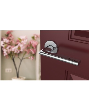 Poignée de porte chrome poli KALMIA poignée design vue inclinée montée sur une porte