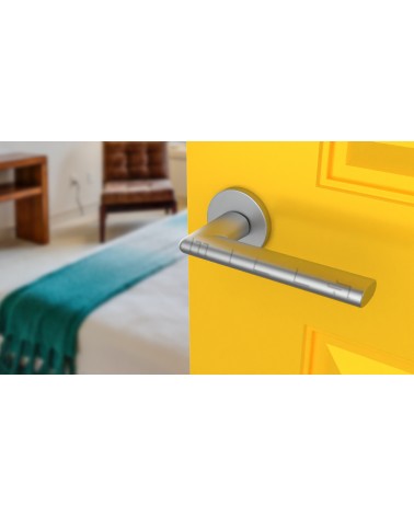 Poignée de porte chrome satiné KALMIA poignée design vue inclinée montée sur une porte