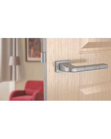 Poignée de porte chrome satiné ISMENA quincaillerie design vue de face montée sur une porte