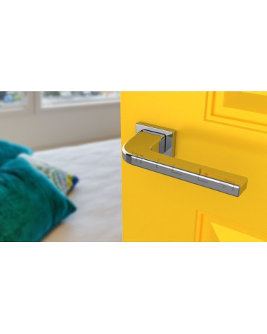 Poignée de porte chrome poli ISMENA quincaillerie design vue inclinée montée sur une porte