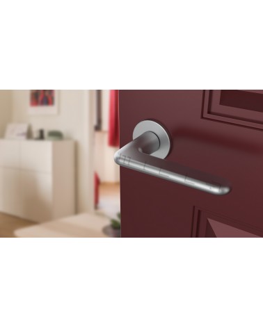 Poignée de porte chrome satiné LIRA poignée design  vue de haut inclinée montée sur une porte