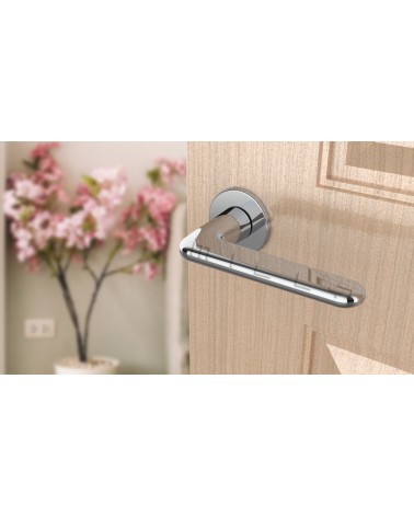 Poignée de porte chrome poli LIRA poignée design vue de haut inclinée montée sur une porte