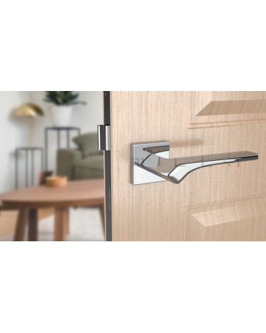 Poignée de porte chrome poli BERGERIA quincaillerie design vue de face montée sur une porte