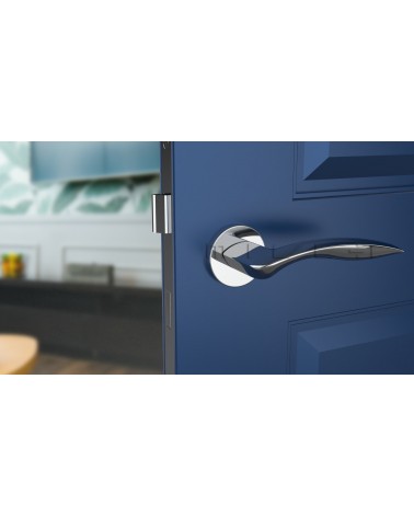 Poignée de porte chrome poli ROBINE quincaillerie design vue de face montée sur une porte