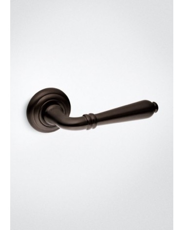Poignée de porte bronze mat Mandelli Sevilla poignée design posée sur un fond