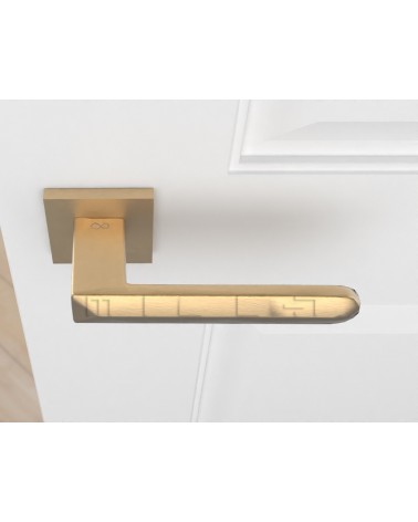 Poignée de porte or mat BOHEMA sur une porte blanche, vue d'en haut