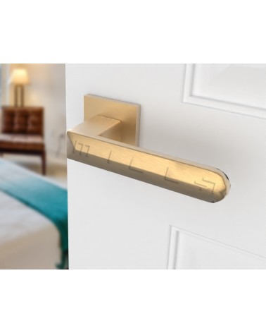 Poignée de porte or mat BOHEMA sur une porte blanche, de coté droite
