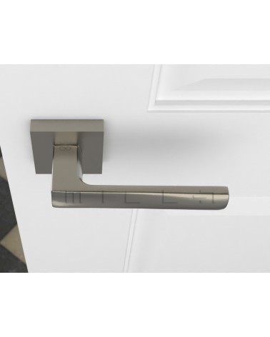 Poignée de porte nickel satiné DIUNA poignée design vue de haut montée sur une porte