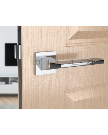 Poignée de porte chrome poli ETNA quincaillerie design vue de face montée sur une porte