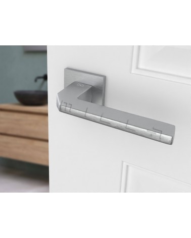 Poignée de porte chrome satiné ETNA quincaillerie design vue inclinée montée sur une porte