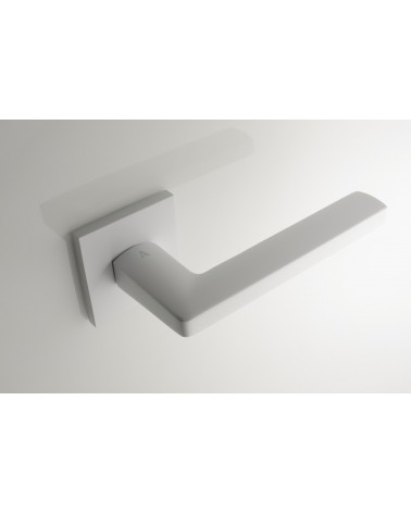Poignée de porte blanche PYROLA quincaillerie design vue de haut inclinée montée sur une porte
