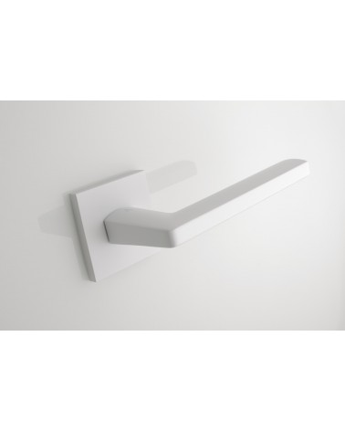 Poignée de porte blanche PYROLA quincaillerie design vue de haut inclinée dézoomée montée sur une porte