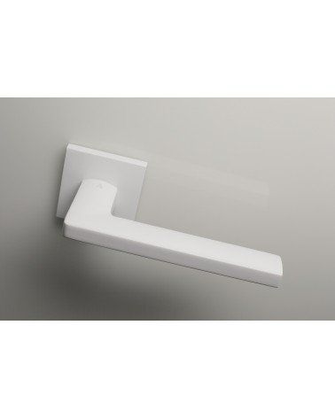 Poignée de porte blanche PYROLA quincaillerie design vue de haut poignée inclinée vers le bas montée sur une porte