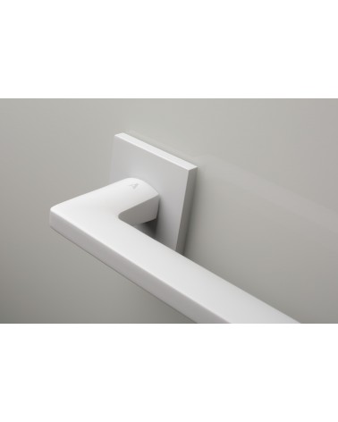 Poignée de porte blanche PYROLA quincaillerie design vue zoomée sur poignée montée sur une porte