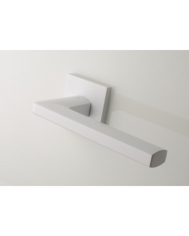 Poignée de porte blanche PYROLA quincaillerie design vue sur poignée inclinée vers le bas montée sur une porte