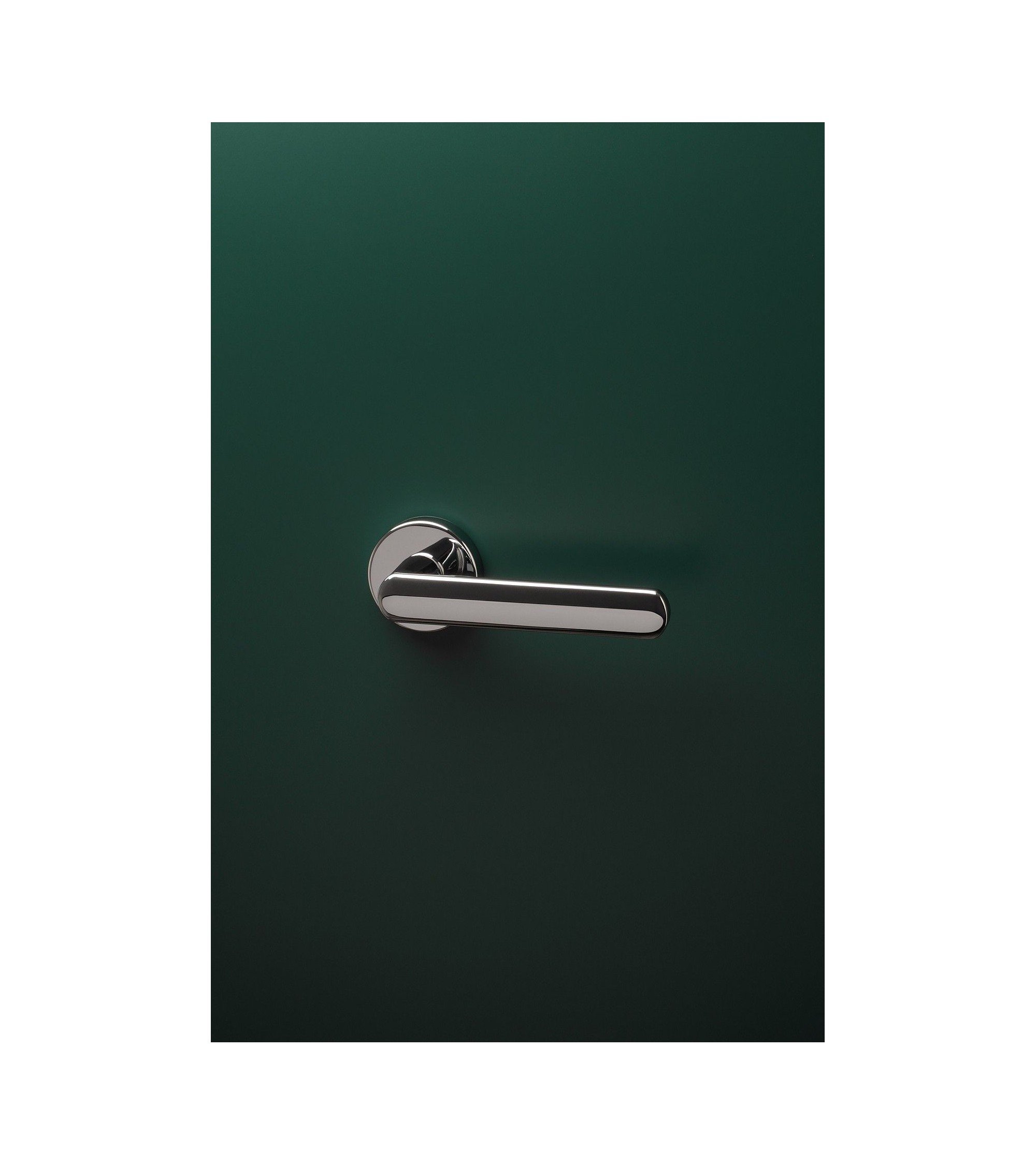 poignée d'intérieur design en finition chrome poli montée sur une porte de couleur verte