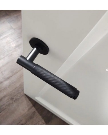 Poignée de porte noire Time Slim poignée design montée sur une porte entrouverte vue de haut