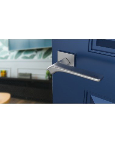 Poignée de porte chrome satiné BERGERIA quincaillerie design vue inclinée montée sur une porte