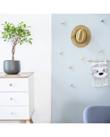 Bouton de meuble en bois de hêtre orange poignée design installée sur une commode blanche surmontée d'une plante en pot